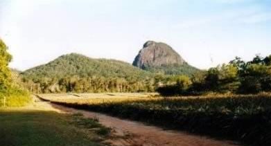 Glass House Mountains Mount Tibrogargan from the behind note the large muscluar backand head  and a Long Barrow in the foreground This area was hit by a MASSIVE tidal wave varst areas of low land is all beach sand.jpg