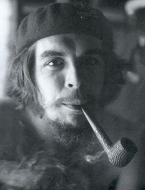 Smoking a pipe at his guerrilla base in the Escambray Mountains.png