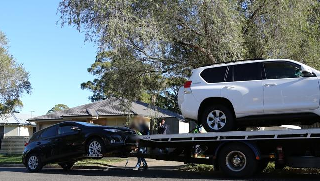 Police seize cars from the womans Western Sydney home as she is led away by police.png