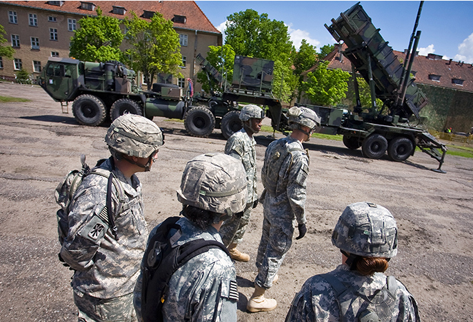 US soldiers stand in front of a Patriot missile battery at an army base in the northern Polish town of Morag.png